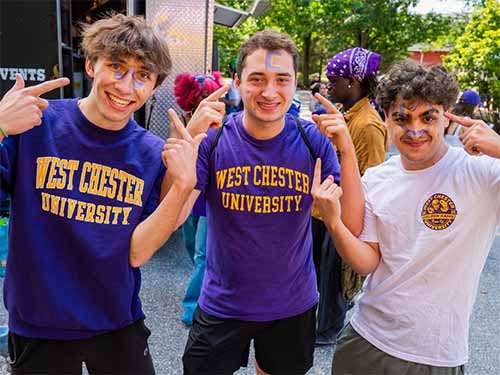 Thumbnail: Three smiling West Chester University students, standing together outdoors, each pointing to letters painted on their foreheads — “W,” “C,” and “U” — wearing WCU shirts, showing school spirit.