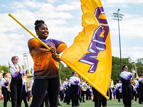 Thumbnail: Close-up of a West Chester University “Incomparable Golden Rams” color guard member, wearing uniform and looking toward the camera with confident expression.
