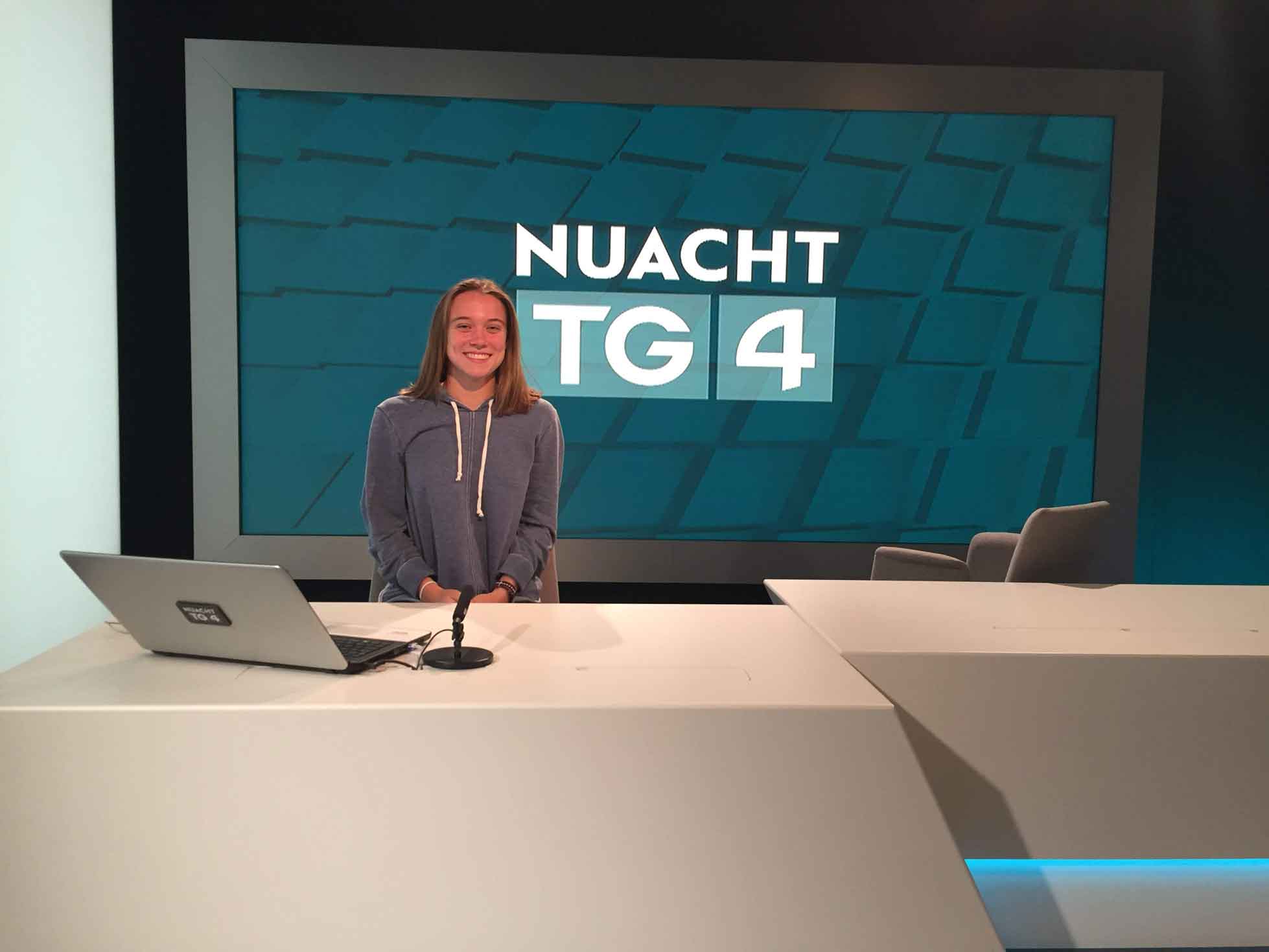 student posing in a news desk