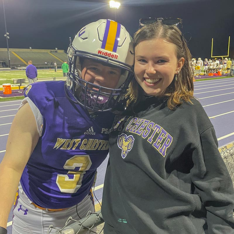 A student with her arm around a football player.