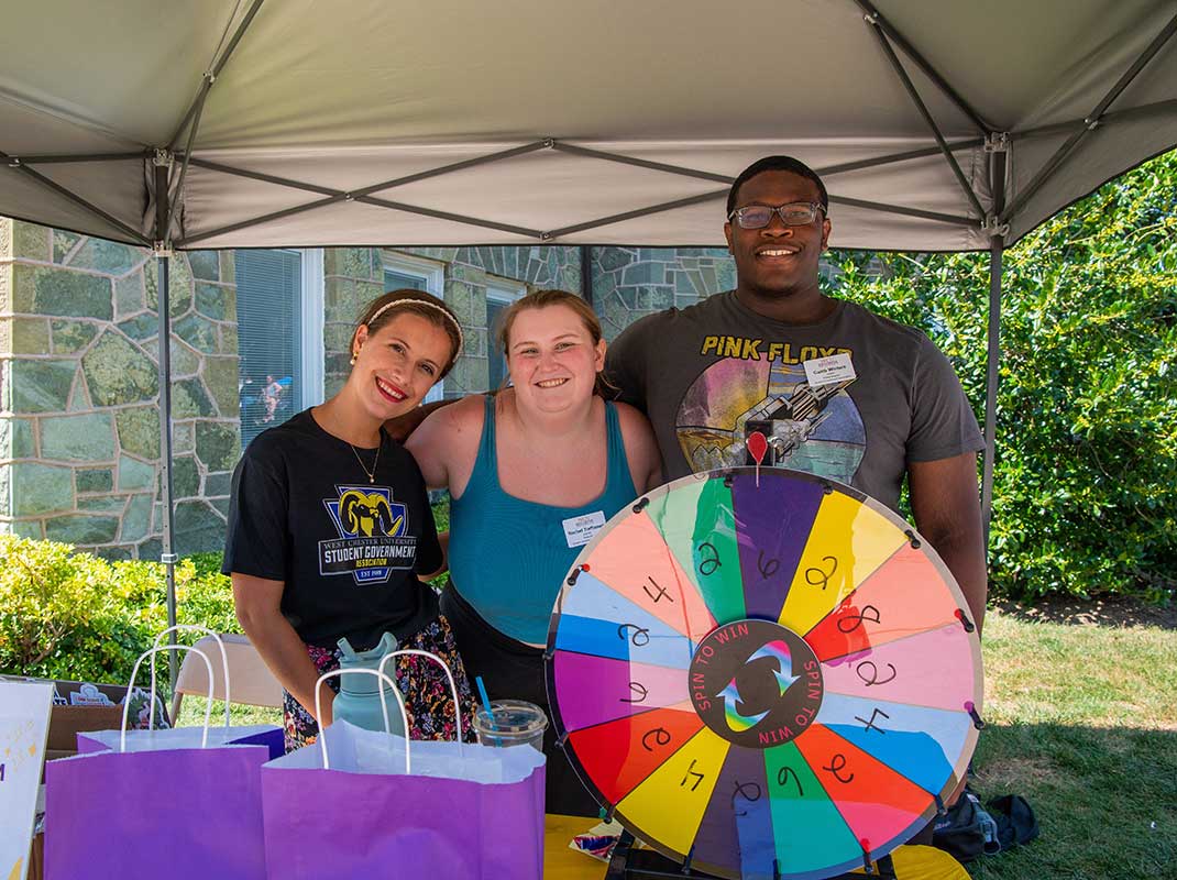 
						SGA Members at the fair with wheel of fortune wheel
					