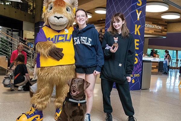 Muddy Puddles (Chocolate lab) poses with rammy and students