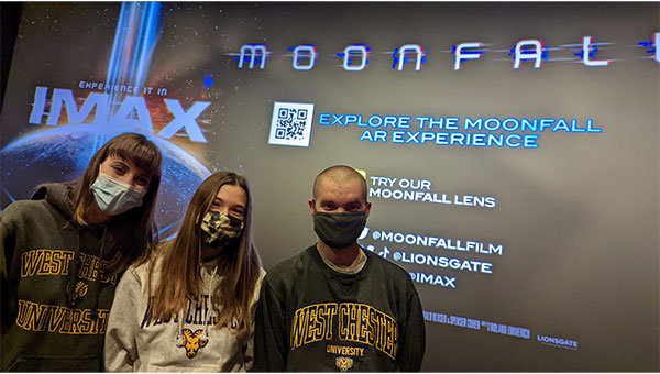 Students standing in front of Moonfall screen