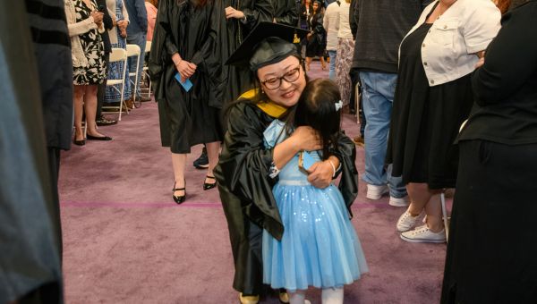 Graduate hugging their child