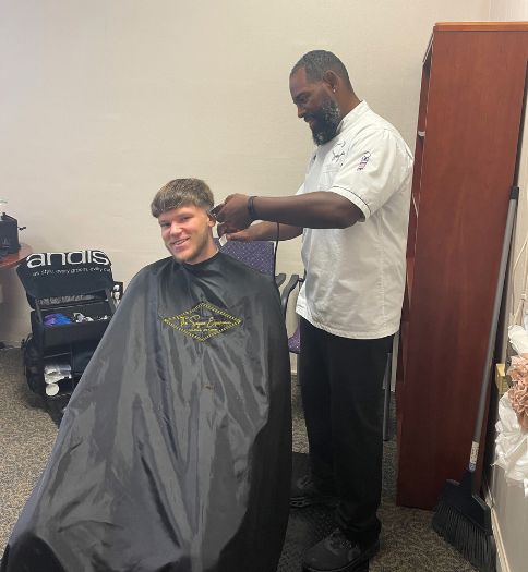 An on-site barber, Soyica White, cut Kayden McCabe’s hair during Prepare for the Fair.