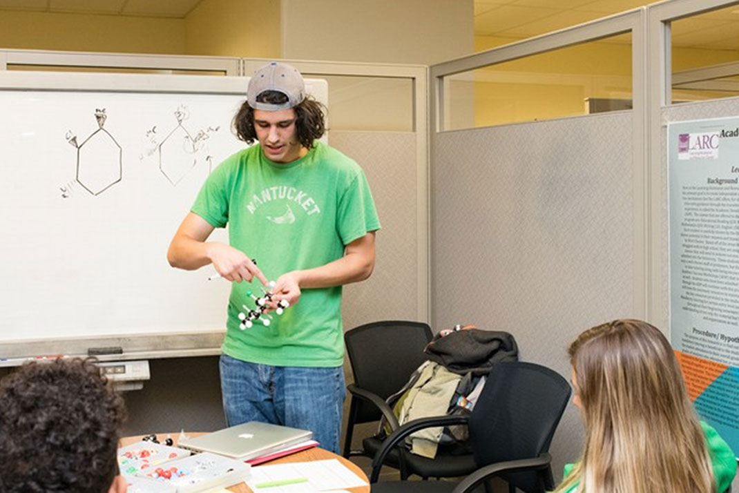 STudent doing a molecule dmonstration in class