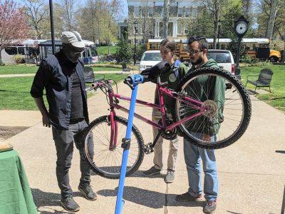 Students learning about bicycle maintenance from a professor