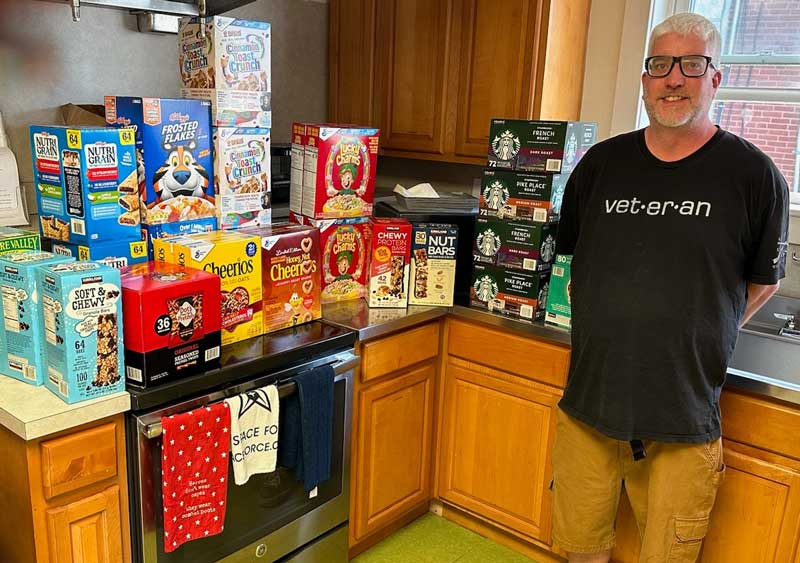 SVG Secretary Jeremy Ruspantine standing with donation of dry good for the Veterans Center